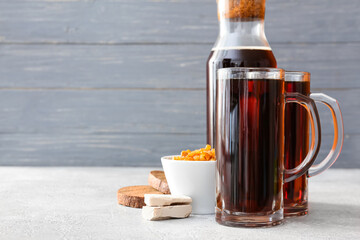 Mugs of fresh kvass on wooden background