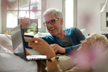 Older couple relaxing together on living room sofa