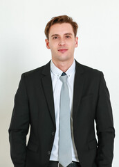 Portrait photo of young businessman in black suit studio shot isolated on white background looking straight at camera with confidence and positvie smile on happy face. Concept for modern man