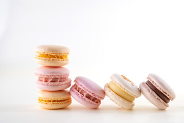 Row of colorful pastel french macaroons or macarons  on white and pink background