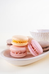 Colorful pastel french macaroons or macarons  with cups on white background