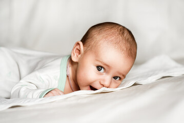 A newborn charming baby in white. Close-up portrait.