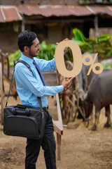 Young indian agronomist or financier showing zero percent sign or symbol at cattle farm