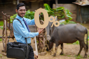Young indian agronomist or financier showing zero percent sign or symbol at cattle farm