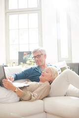 Older couple relaxing together on living room sofa