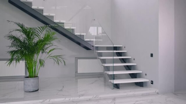 Modern wooden with glass railings stairs in a private house. Smooth first person tracking shot.
