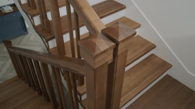 Classic wooden stairs in a private house in warm pastel colors. Smooth first person tracking shot.