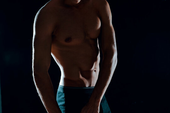 man with muscular abs cropped view of gym dark background