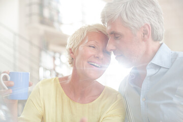 Older couple hugging with coffee cup