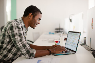 Obraz na płótnie Canvas Man working on laptop at office