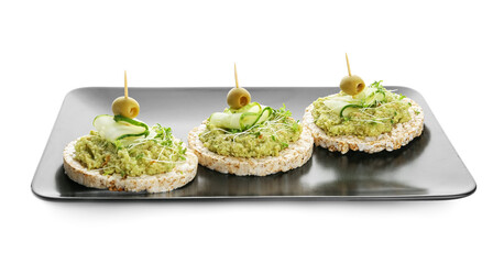 Rice crackers with guacamole, olives and cucumber on white background