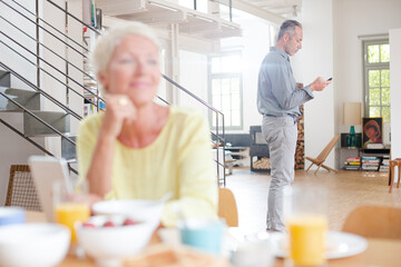 Older woman using digital tablet at breakfast table