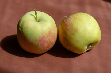 Minimalist composition with apples on a brown background. Ripe r