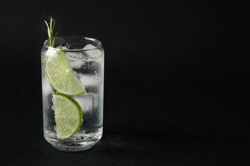 Glass of cold gin and tonic on dark background