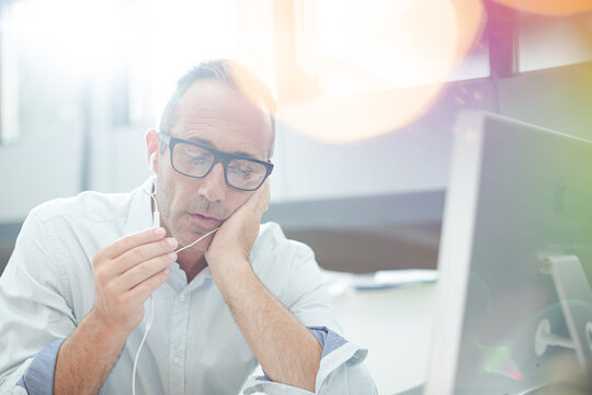 Older Man Working On Computer At Desk