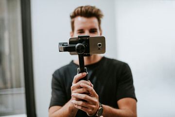 Man holding a gimbal with a phone - obrazy, fototapety, plakaty