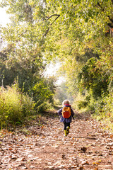 Jeune fille courant sur un sentier au soleil d'automne