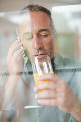 Older man talking on cell phone at breakfast