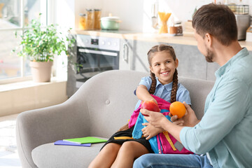 Father getting his little daughter ready for school