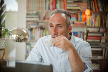 Businessman drinking cup of espresso in home office