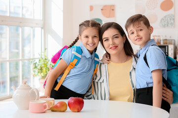 Obraz na płótnie Canvas Little schoolchildren with their mother at home