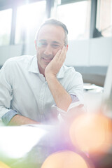 Businessman reading paperwork at home office desk