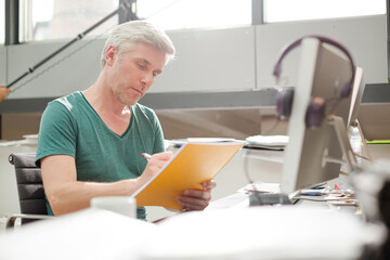 Businessman reading paperwork at office desk