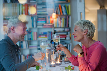 Older couple toasting each other at romantic dinner