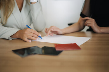 Woman choosing and buying car at car showroom. Car salesman helps them to make right decision. Female sign documents