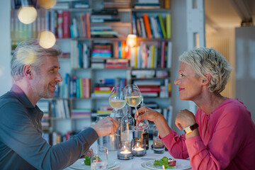 Older couple toasting each other at romantic dinner