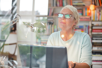 Businesswoman smiling at computer in home office