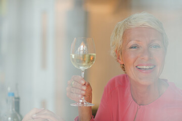 Older woman drinking glass of white wine