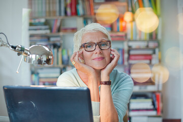 Businesswoman smiling at computer in home office