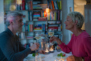 Older couple toasting each other at romantic dinner