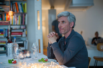 Older man drinking white wine at dinner