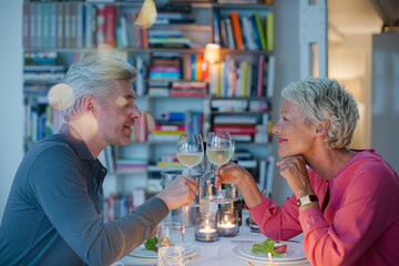 Older couple toasting each other at romantic dinner