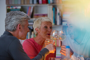Older friends toasting each other with white wine