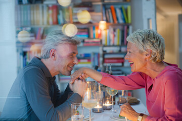 Fototapeta na wymiar Older man kissing hand of wife at romantic dinner