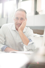 Businessman reading paperwork at home office desk