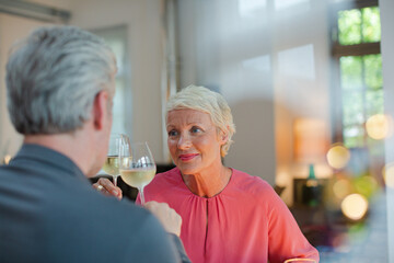 Older romantic couple drinking white wine