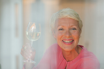 Older woman drinking glass of white wine