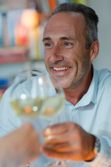 Older man drinking white wine at dinner