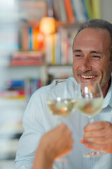 Older man drinking white wine at dinner
