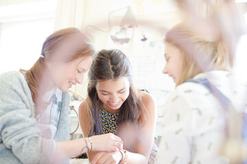 Three teenage girls relaxing in bedroom