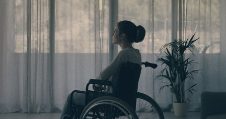 Woman in wheelchair at home alone