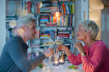 Older couple toasting each other at romantic dinner