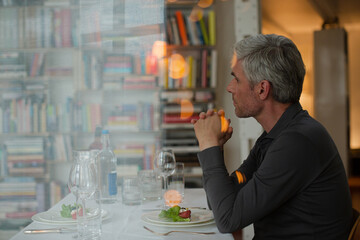 Older man drinking white wine at dinner