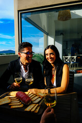 Cheerful woman having wine with man while dining together at table