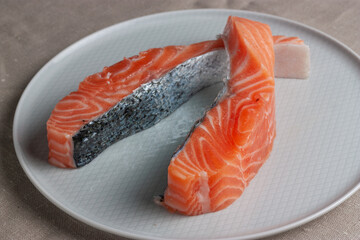 Lomos de Salmón crudo en plato blanco. Concepto gastronomía minimalista. Textura piel de pescado.