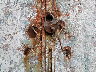 background of very old metal garage doors with rusty barn lock and handles
